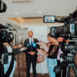 Giornalisti e telecamere durante un’intervista a un manager in un contesto professionale